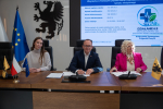 Wicemarszałek Marcin Skwierawski oraz dwie przedstawicielki lokalnych władz siedzą przy stole prezydialnym i podpisują umowę o dofinansowanie