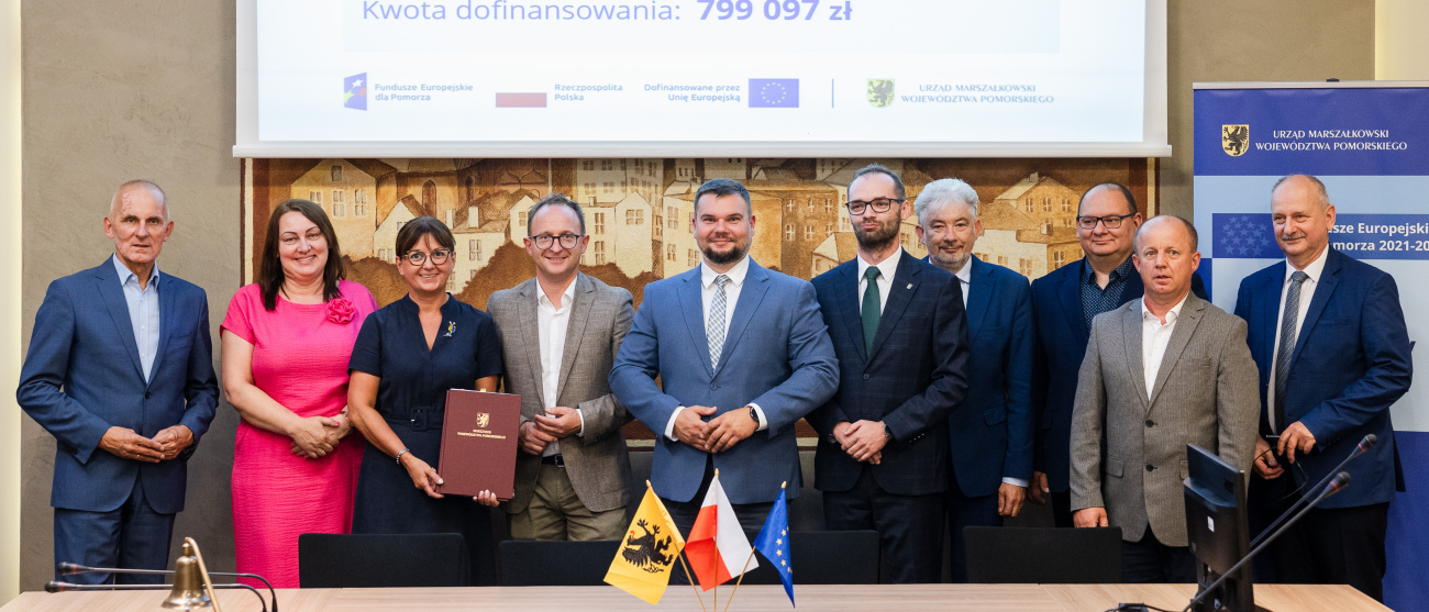 Grupa ludzi za stołem w tle ekran