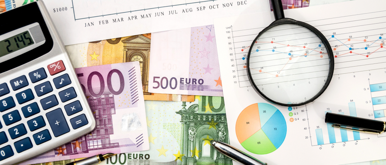 papiery, pieniądze, lupa i kalkulator leżą na stole
