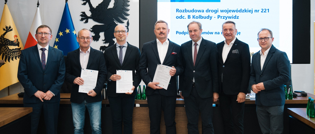 siedmiu mężczyzn prezentuje podpisane umowy