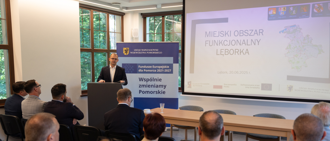 sala, ludzie, ekran z informacją o projekcie 