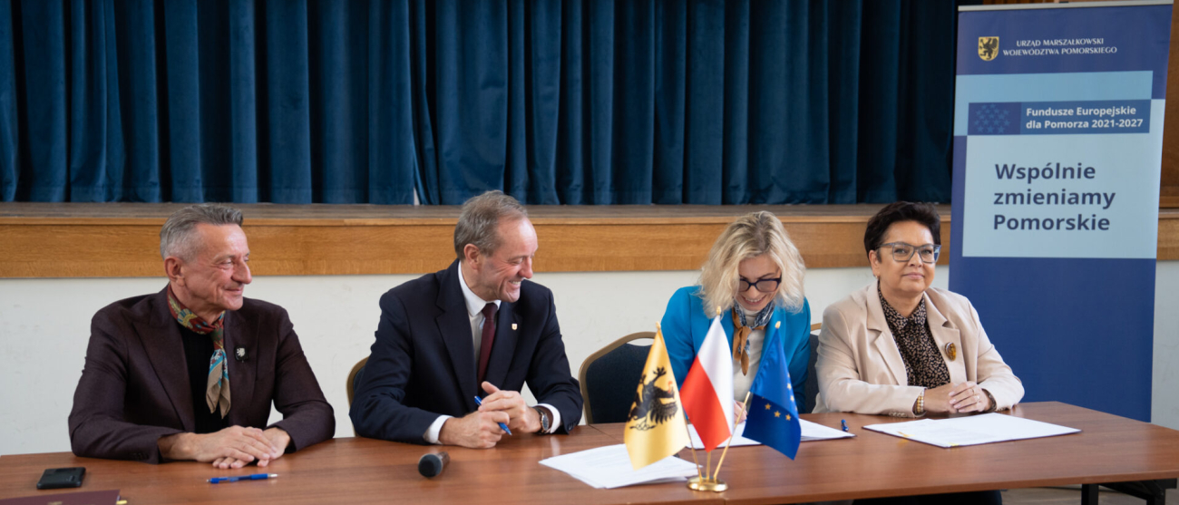 Marszałek Leszek Bonna oraz Mieczysław Struk. Siedzą przy stole. Po prawej dwie kobiety - przedstawicielki beneficjenta. Podpisują umowę. 