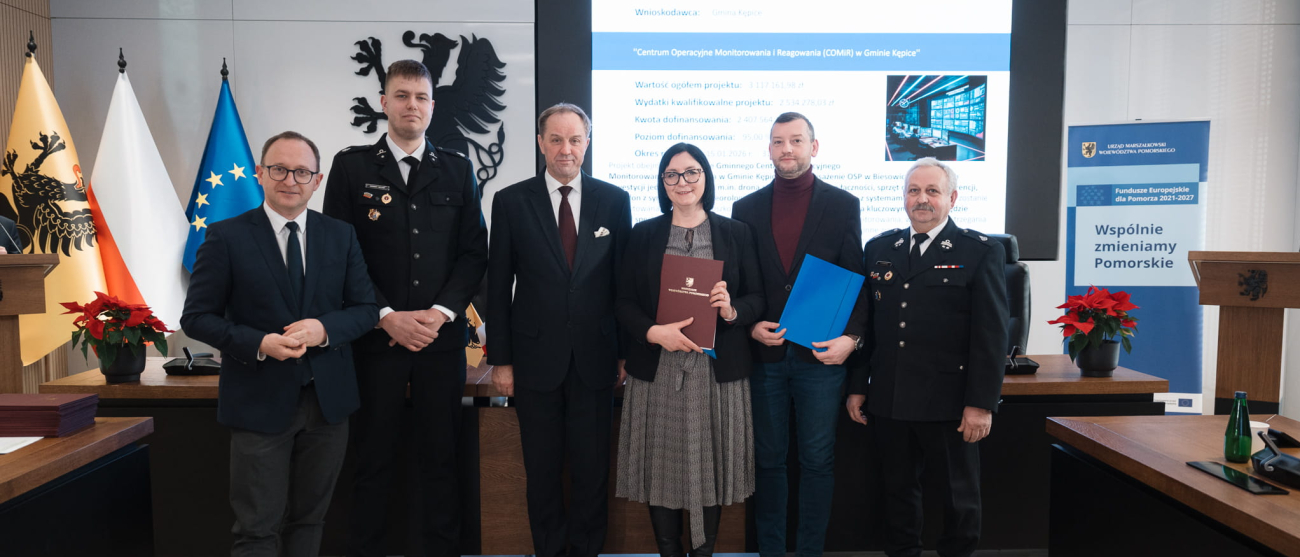 sześć osób prezentuje podpisaną umowę