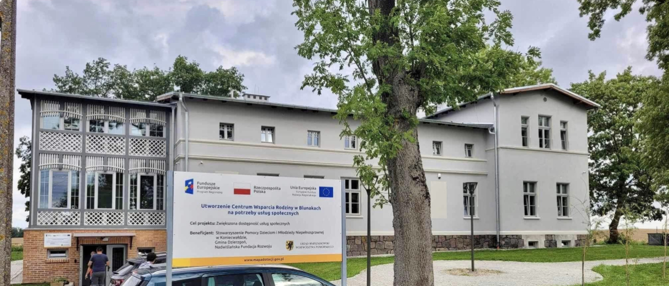 budynek Centrum, tablica informacyjna, auto w tle