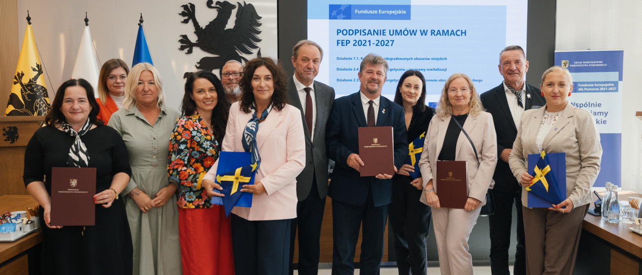 Marszałek Mieczysław Struk, wicemarszałek Leszek Bonna oraz przedstawiciele powiatu starogardzkiego, Miasta Malborka i Gminy Gardeja pozują do pamiątkowego zdjęcia, prezentując podpisane umowy i flagi Unii Europejskiej.
