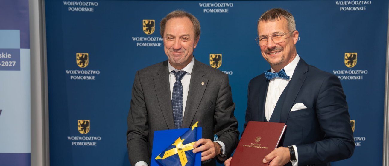 dwie osoby prezentują podpisaną umowę